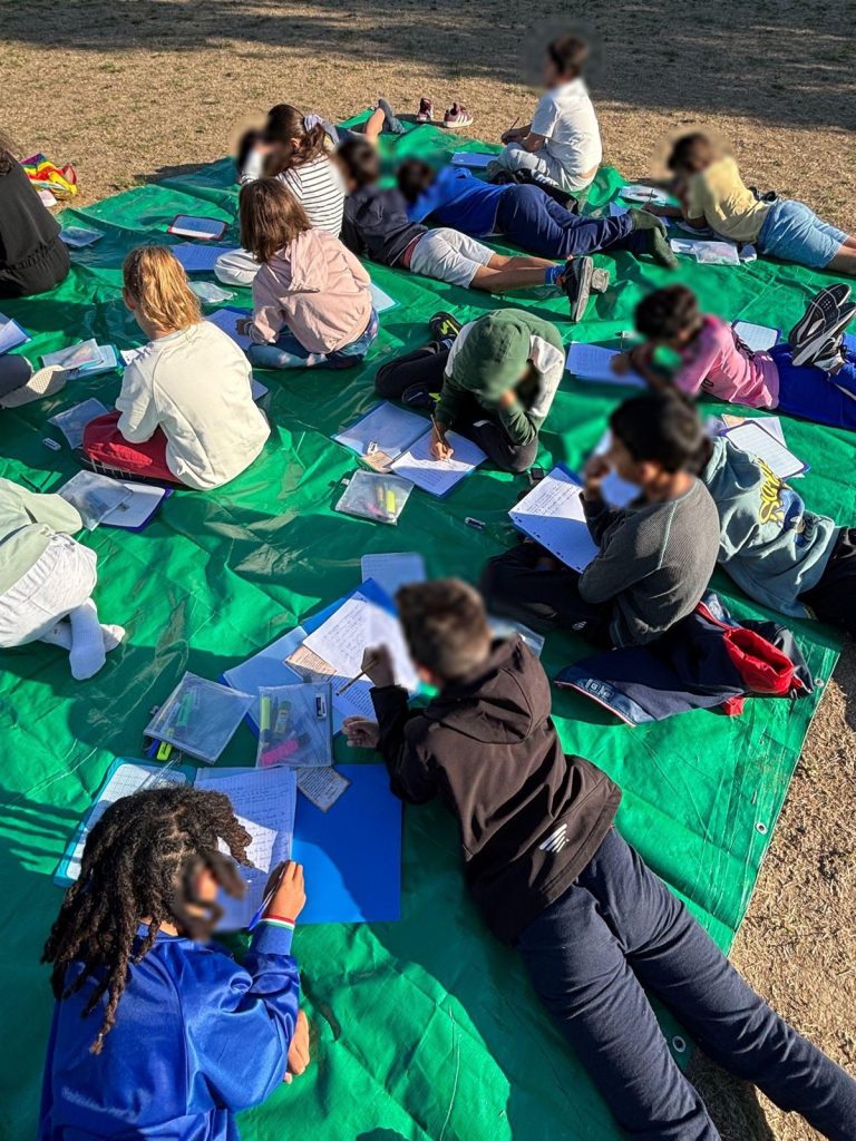 Des élèves réalisent une activité d'écriture en plein air